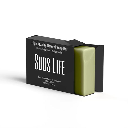 A bar or Suds Life Aloe Butter Natural Soap that is green in color and is inside a black box with a white background.
