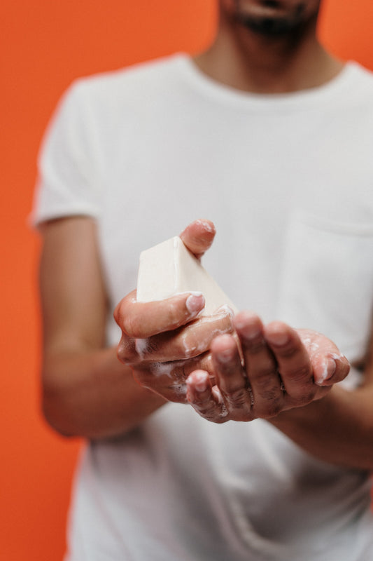 An image of a man holding a bar of natural soap.